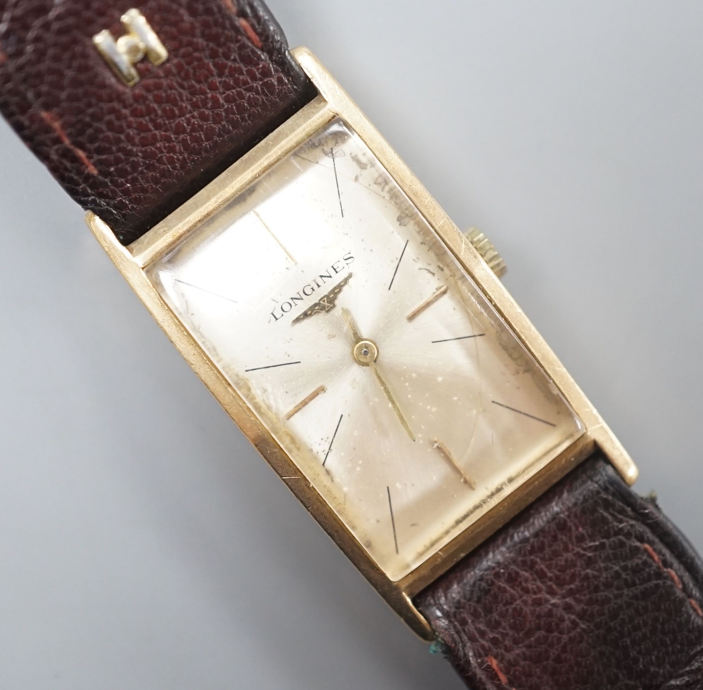 A gentleman's 14k Longines manual wind rectangular dial wrist watch, case diameter 20mm, on associated leather strap.